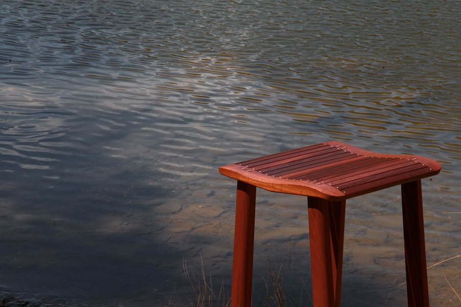 Handmade timber stool sitting beside the Molonglo River in the Australian landscape