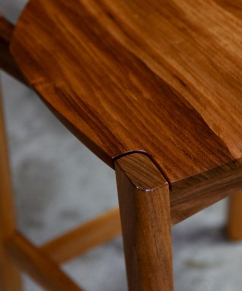 A high stool with a back rest designed for Australian houses and made from native timbers.