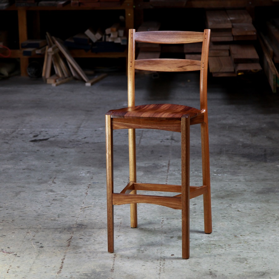 A high stool with a back rest designed for Australian houses and made from native timbers.