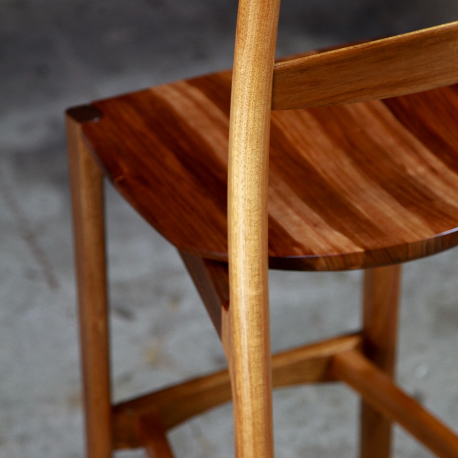 A high stool with a back rest designed for Australian houses and made from native timbers.