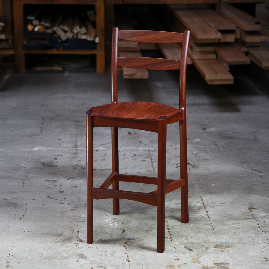 A high stool with a back rest designed for Australian houses and made from native timbers.