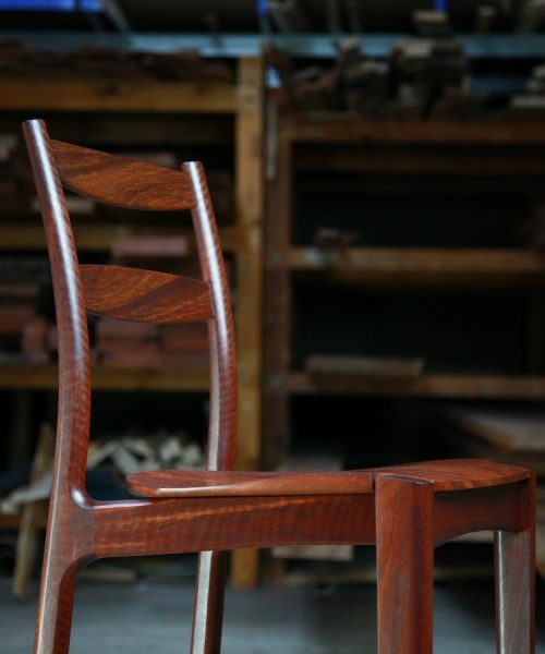 A high stool with a back rest designed for Australian houses and made from native timbers.