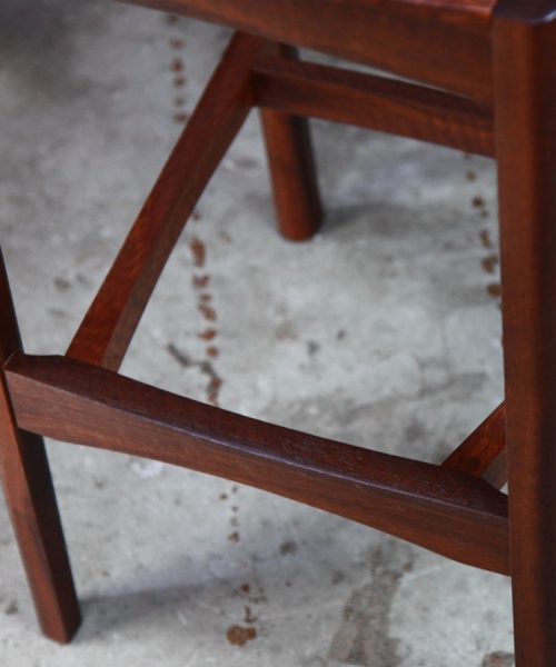 A high stool with a back rest designed for Australian houses and made from native timbers.