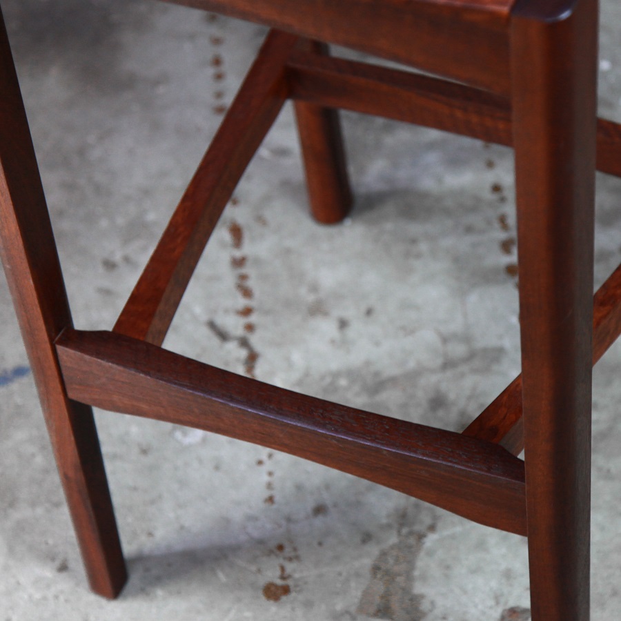A high stool with a back rest designed for Australian houses and made from native timbers.
