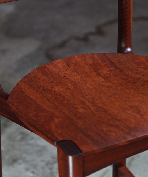 A high stool with a back rest designed for Australian houses and made from native timbers.