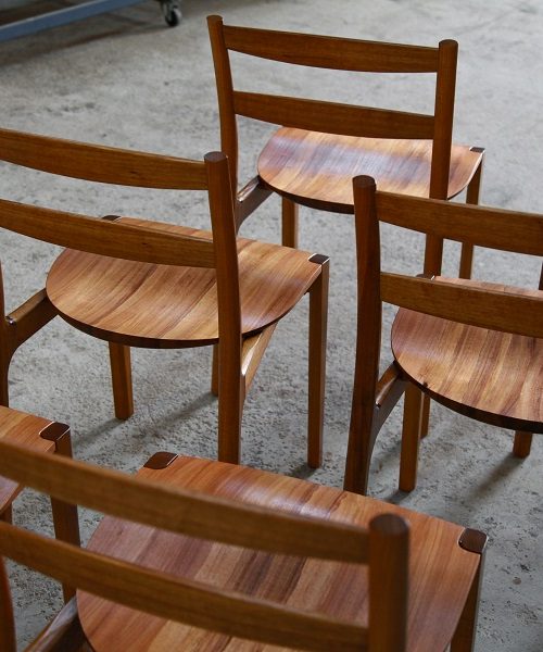 A set of Australian designed and made low back dining chairs in Tasmanian blackwood in a woodworking workshop.