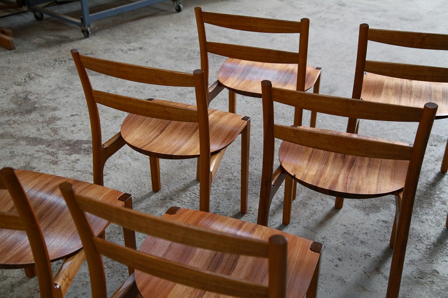 A set of Australian designed and made low back dining chairs in Tasmanian blackwood in a woodworking workshop.