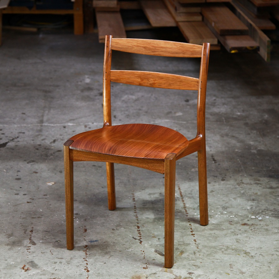An Australian designed and made low back dining chair in Tasmanian blackwood in a woodworking workshop.