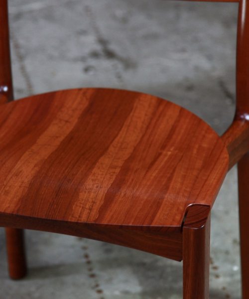 An Australian designed and made low back dining chair in jarrah in a woodworking workshop.
