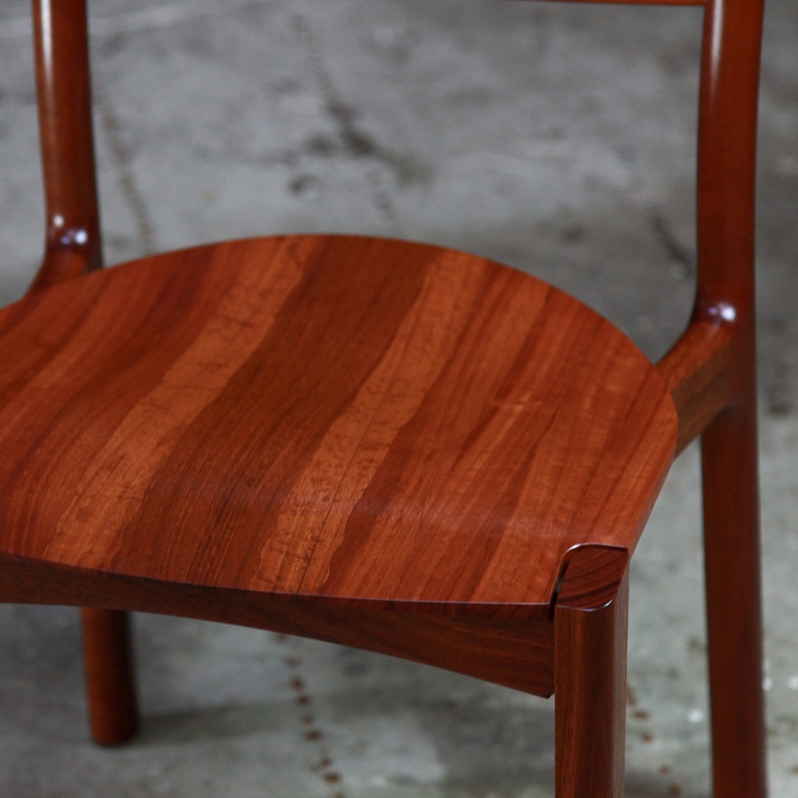 An Australian designed and made low back dining chair in jarrah in a woodworking workshop.