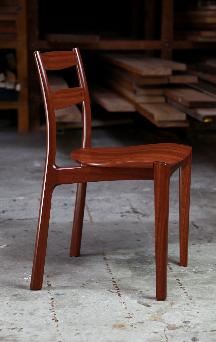 An Australian designed and made low back dining chair in jarrah in a woodworking workshop.