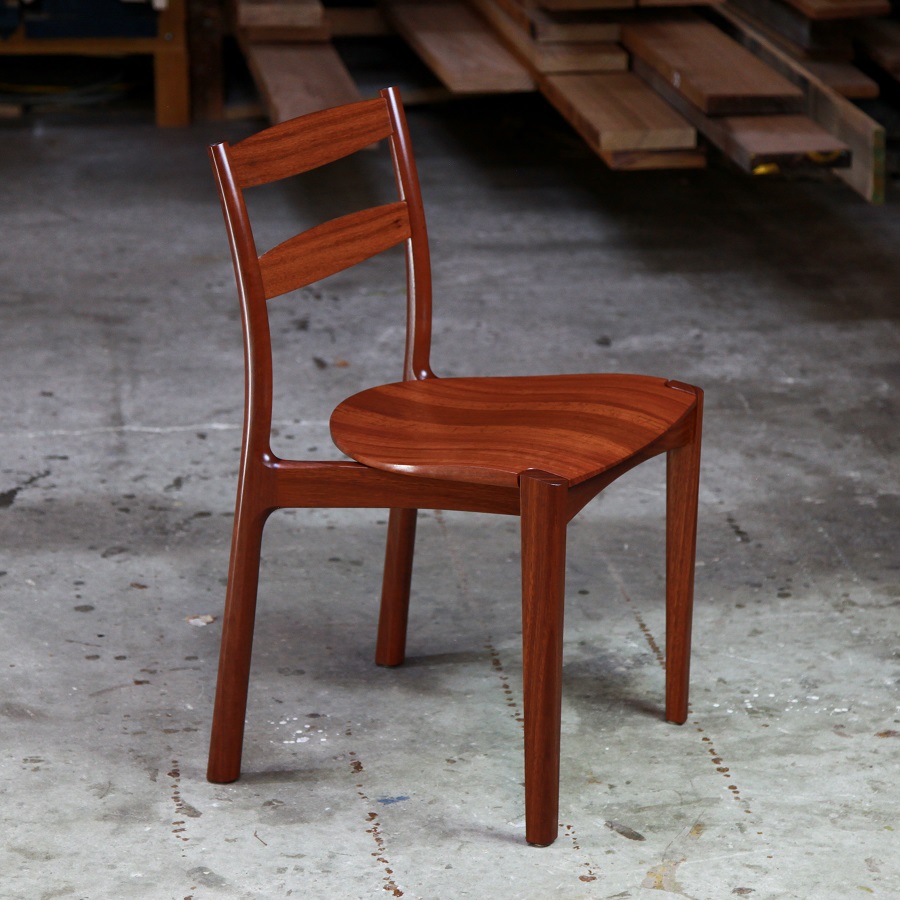 An Australian designed and made low back dining chair in jarrah in a woodworking workshop.