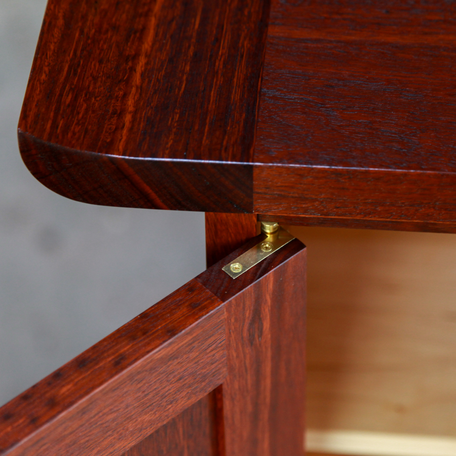 Door detail of a brass Brusso hinge fitted to beautiful jarrah cabinet.