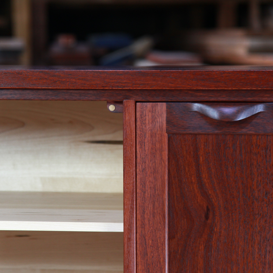 Door detail of a jarrah and rock maple cabinet featuring a hand made door pull.