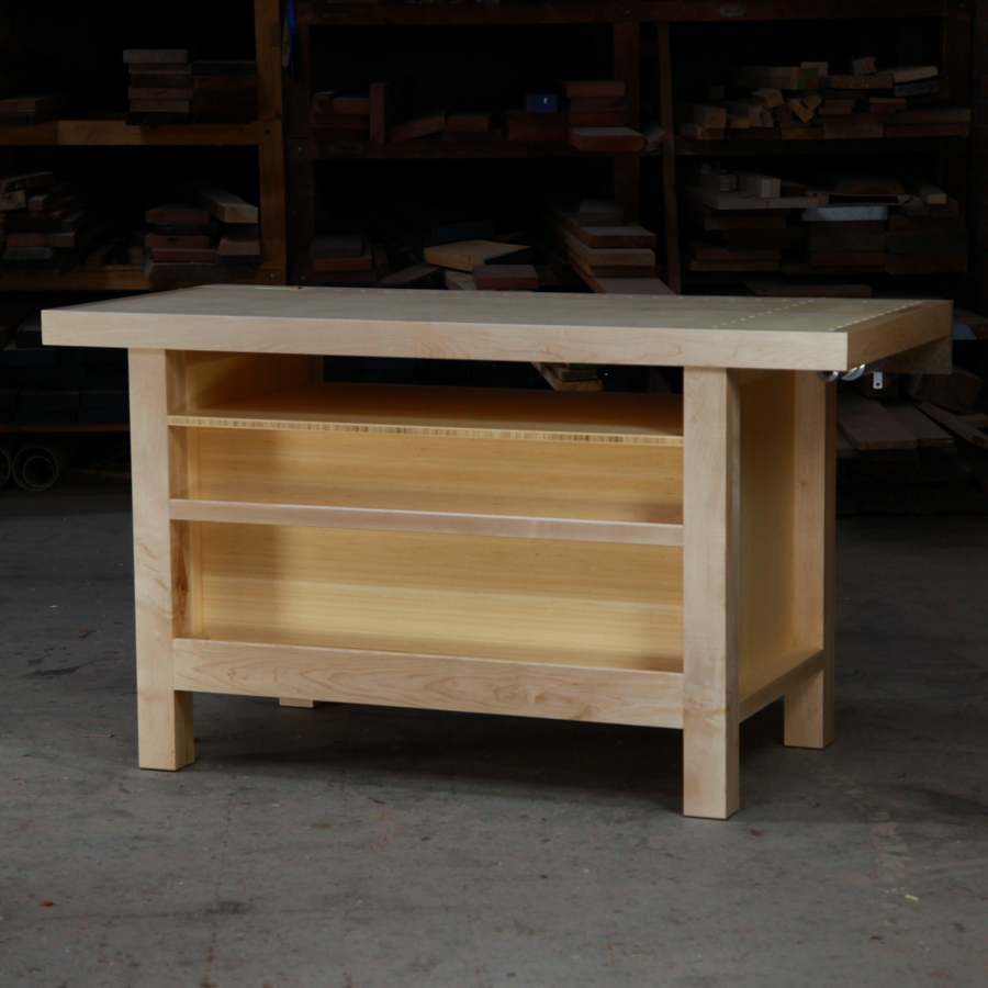 A beautiful woodworking bench sits in the workshop in front of a timber rack