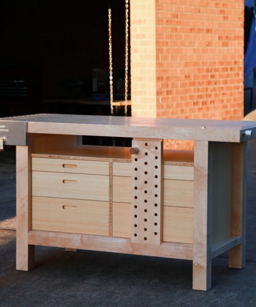 A beautiful woodworking bench catches the evening winter sun out the front of a workshop.